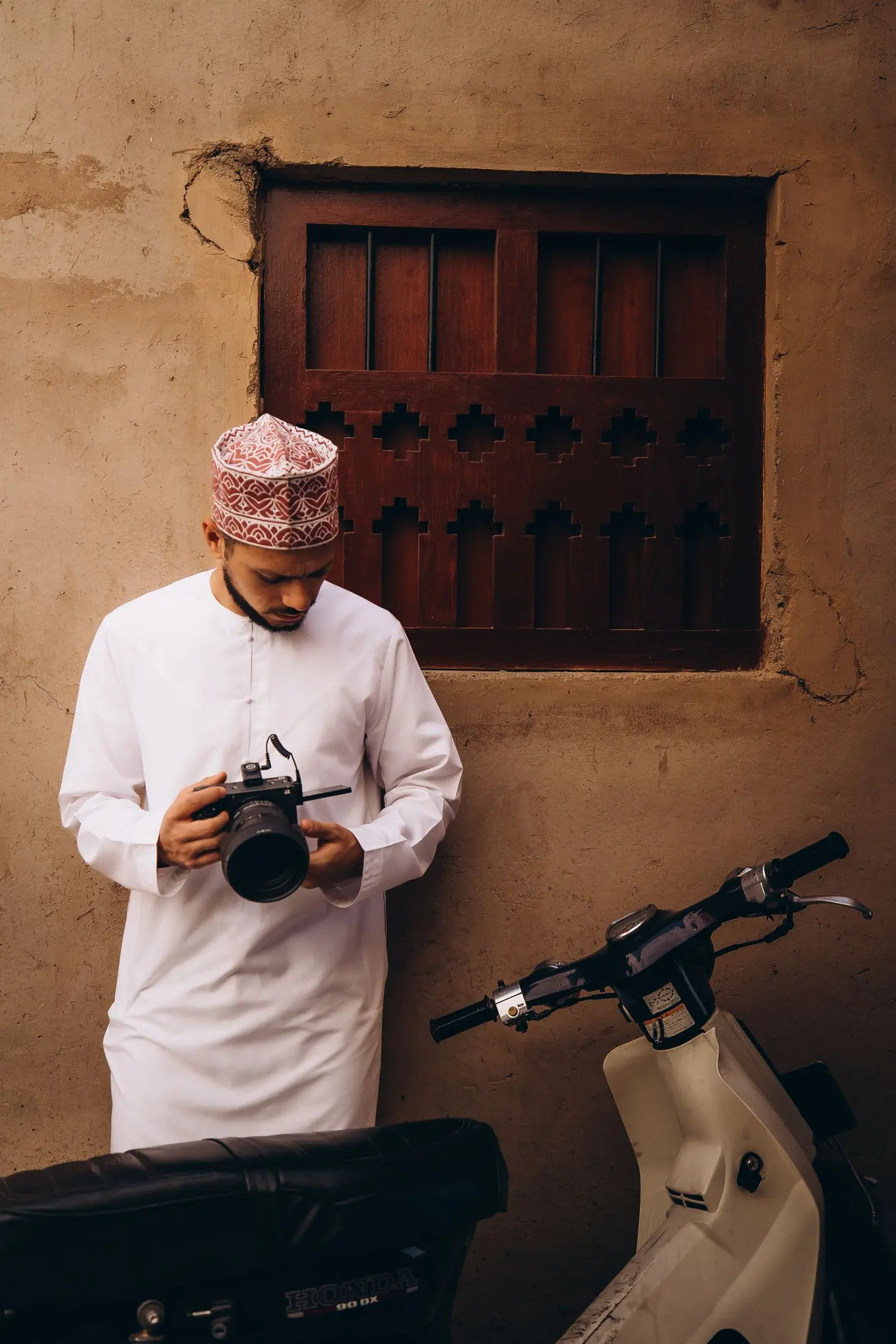 Omani photographer in traditional clothing with camera